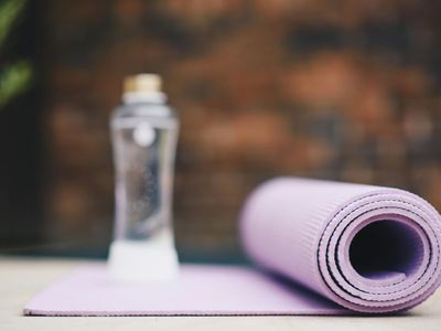 A rolled yoga mat and a bottle of water.